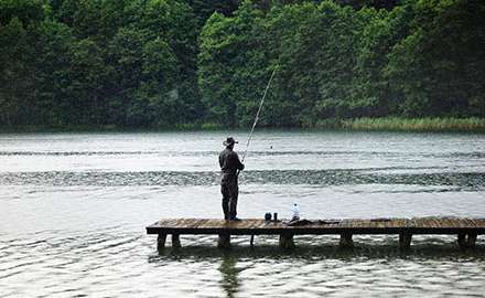a man is fishing at the lake