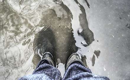 A pair of rubber rain boots in water